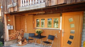 A wooden building with a large door, a window with three panes, and a small table with two chairs. - in Stäfa by Interhome (Mutzmalen)
