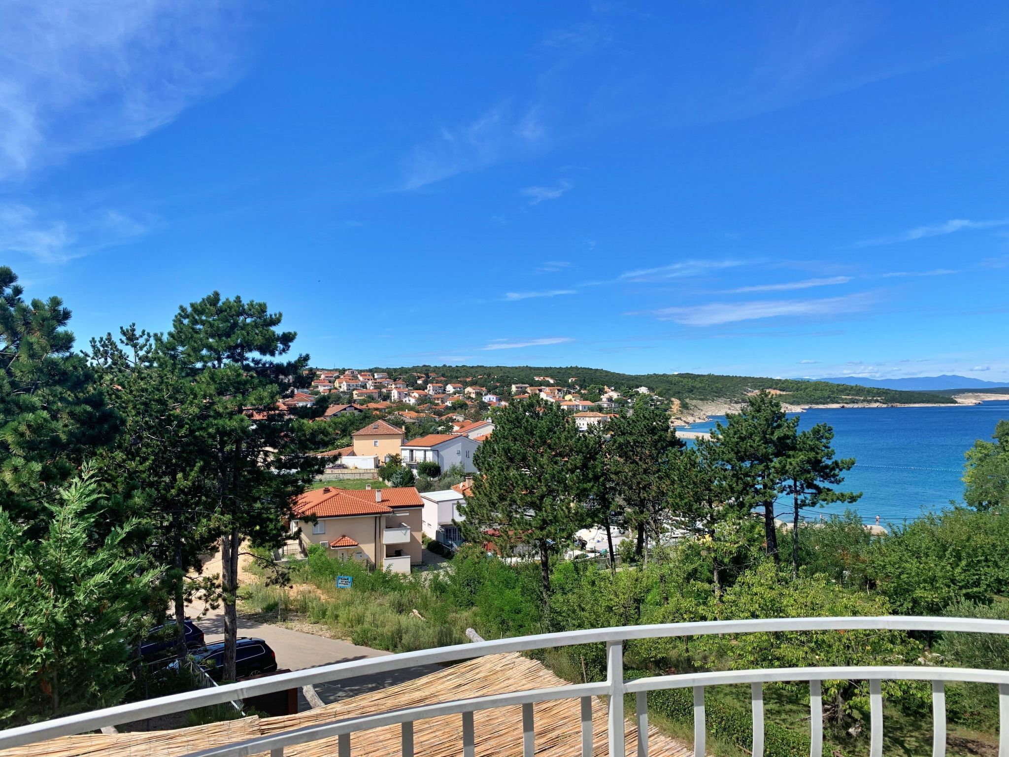 A coastal town with houses, a beach, and a clear blue sky.