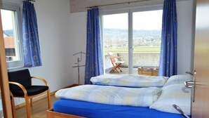 Une chambre à coucher avec un lit, une chaise et une vue sur la ville.
