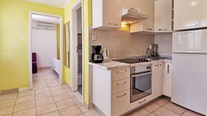 Una cucina moderna con mobili bianchi, forno integrato e macchina da caffè.