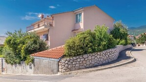 Un bâtiment à deux étages, doté d’un mur en pierre et d’un toit recouvert de tuiles rouges.
