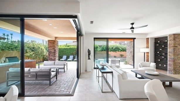 A modern living room with a glass door leading to an outdoor patio area. - Marvelous 4-bed resort style house with panoramic Mountain Views in La Quinta (La Quinta)