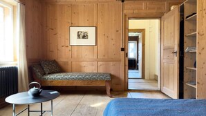 A wooden room with a bed, a bench, a table with a kettle, and a wardrobe. - Haus Walli-Simmen, Wohnung 2 by Interhome (Fideris)