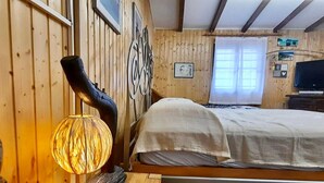 Une pièce de style cabane en bois, avec un lit, un élément décoratif mural et une lampe rustique.