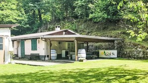 Un bâtiment de style rustique doté d’un patio couvert, de sièges en plein air et d’une enseigne indiquant qu’il s’agit d’un établissement d’hébergement.