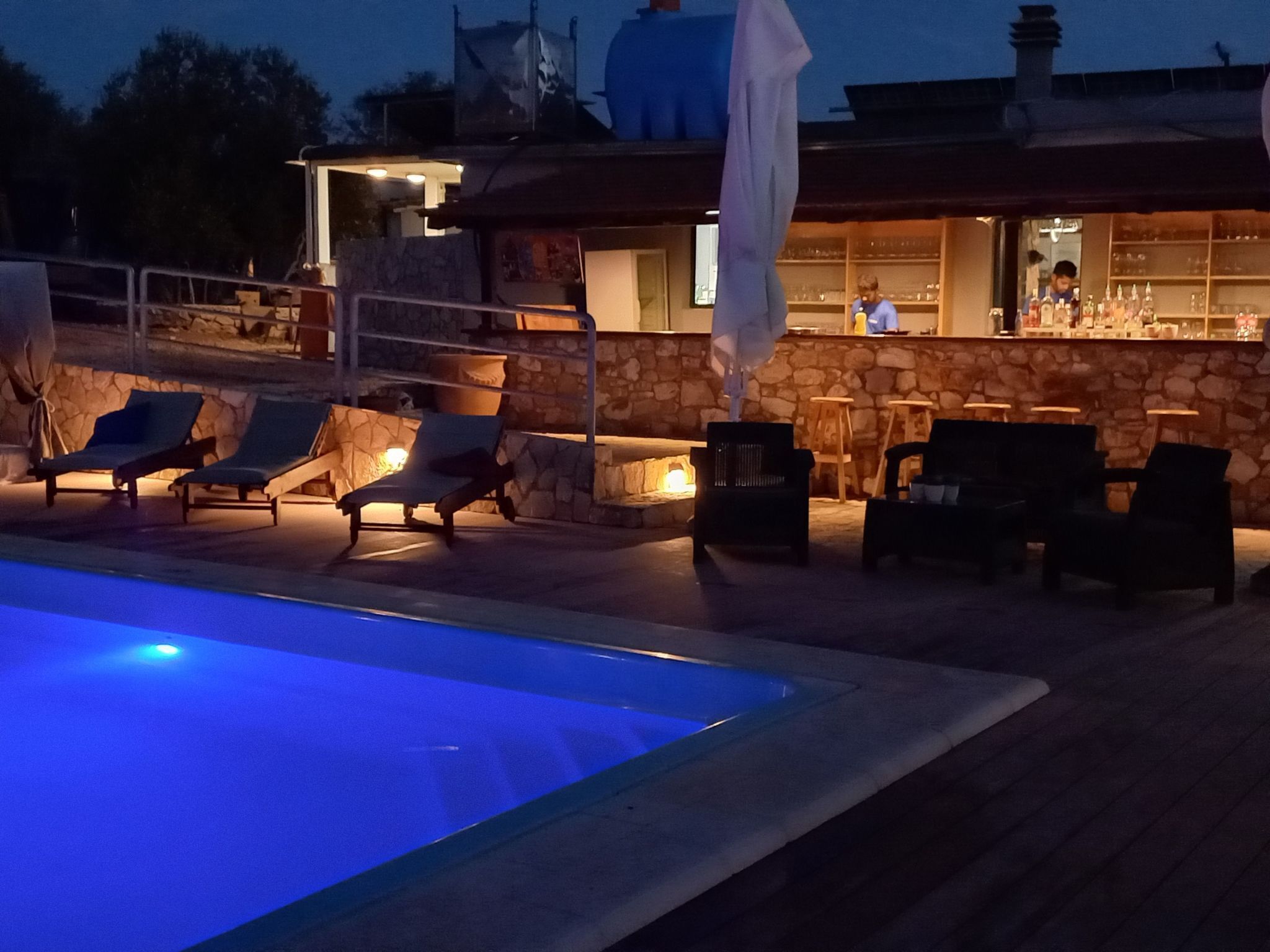 A pool area with lounge chairs and a bar.