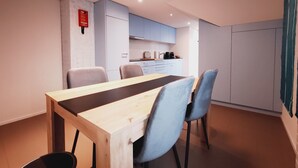 Une cuisine moderne avec des meubles de couleur bleu clair, une table à manger en bois et des chaises bleues.
