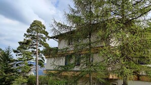 A two-story building with a garden in front. - Casa Bambi 6.5 Zimmer by Interhome (Pfäfers)
