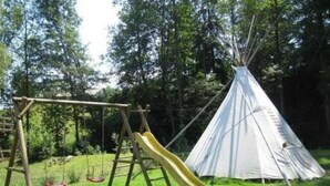 A playground with a swing set and a slide, and a white teepee in a grassy area. - Farbhaus Bleiche by Interhome (Rohrbach)