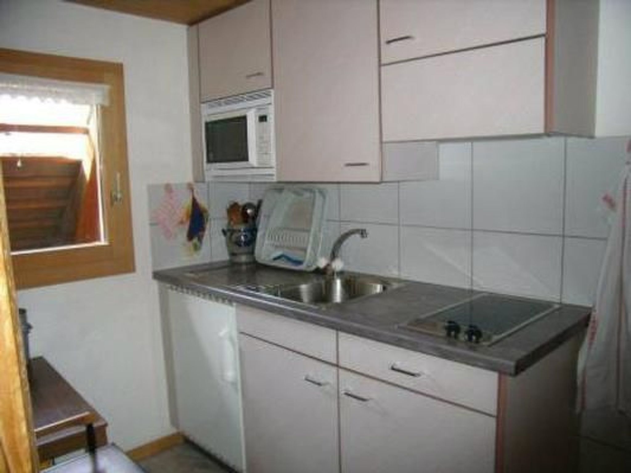 Een koelkast, een microgolfoven, kookgerei, borden en bestek