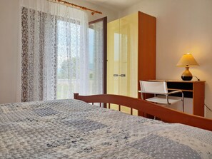 A bedroom with a bed, a wooden desk, a chair, a wardrobe, and a lamp. - Apartment Bijelic - 480 Meter vom Meer by Interhome (Krk/Šilo)