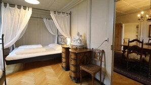 Une chambre à coucher comprenant un lit, une chaise, une table de chevet et une statue décorative.