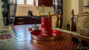 Una mesa de comedor con mantel de lunares, una lata roja de Coca-Cola y un par de gafas de sol.