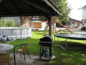 A covered outdoor area with a trampoline, a barbecue grill, and a table with chairs. - Sidlers Neuhof by Interhome (Sins)