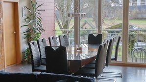 Un espace repas avec une grande fenêtre en verre, une table et des chaises.