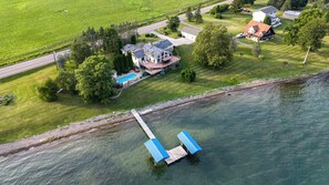 Vue aérienne d’une propriété comprenant une maison, un quai et une piscine.