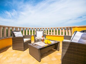 An outdoor patio with wicker furniture, a table, and a bottle of wine. - Villa "Mile" mit beheiztem Pool, Grill und Terrasse by Interhome (Katuni)
