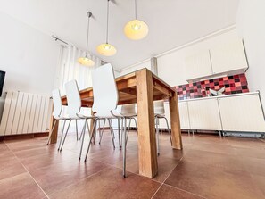 A modern kitchen with white cabinets, a wooden dining table, and pendant lights. - LacoDeLama mini resort - Wohnung Marta mit Pool by Interhome (Medulin/Ližnjan)