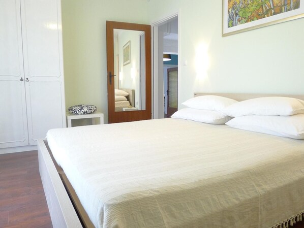 A bedroom with a bed, a bedside table, a mirror, and a door leading to another room. - LacoDeLama mini resort - Wohnung Marta mit Pool by Interhome (Medulin/Ližnjan)