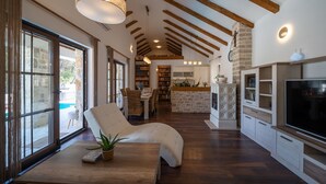 Un vaste espace de vie comprenant une table à manger en bois, des sièges confortables, une cheminée et un téléviseur.