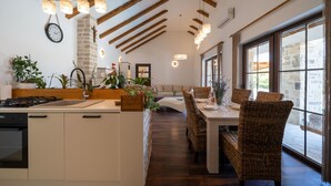 Une cuisine moderne dotée d’un îlot central, de poutres en bois et de luminaires suspendus.