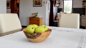 Ein Esstisch mit einer Holzschale, gefüllt mit grünen Äpfeln und Schokoladencreme.