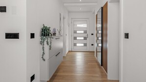 A modern hallway with white walls, wooden flooring, and a door with frosted glass panels. - Villa Lejla by Interhome (Drenje)