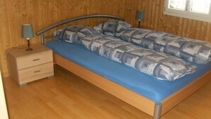 A single-bed room with a wooden floor, a blue mattress, and two bedside lamps. - Ferien im grünen links by Interhome (Haldi b. Schattdorf)