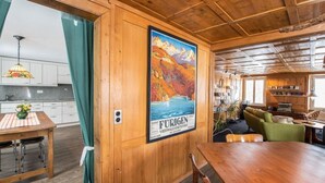 Un interno in legno con zona pranzo, cucina e soggiorno.