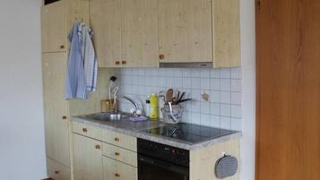 Een koelkast, een magnetron, een oven, kookgerei, borden en bestek