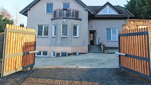 A two-story house with a balcony, a gated driveway, and a paved entrance. - Wellness Villa near Prague - all inclusive by Interhome (Vranov)