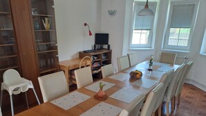 A dining area with a wooden table, white chairs, and a glass cabinet. - Wellness Villa near Prague - all inclusive by Interhome (Vranov)