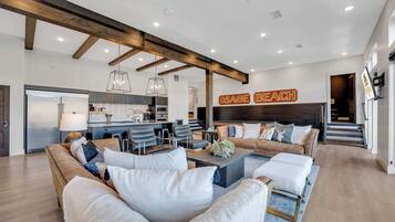 A spacious living area with a modern kitchen, a large sofa set, and a decorative sign reading "OSAGE BEACH".