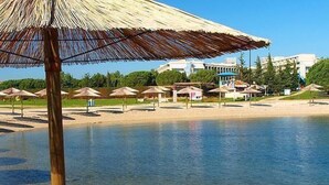 A beach with umbrellas and a pool. - Appartement mit zwei Terrassen mit Meerblick by Interhome (Novigrad (Istra))