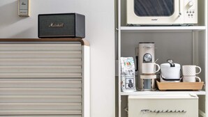 Eine Küche mit Kaffeemaschine, Mikrowelle und einem Schrank.