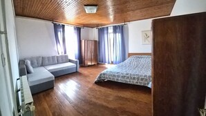 A bedroom with a wooden ceiling, a sofa, a bed, and a wardrobe. - mit Kamin in der Stadt Roc by Interhome (Roč)