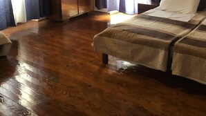 A room with wooden flooring, a bed with a striped blanket, a wardrobe, and curtains on the windows. - mit Kamin in der Stadt Roc by Interhome (Roč)