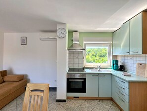 Een koelkast, een oven, kookgerei, borden en bestek