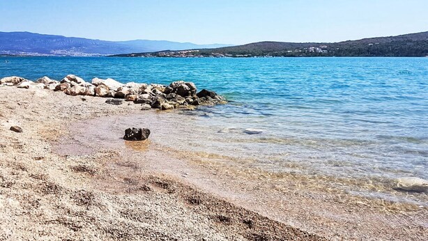 A beach with clear water, rocky shoreline, and distant hills. - Insel Krk - Restauriertes  Steinhaus by Interhome (Krk/Čižići)