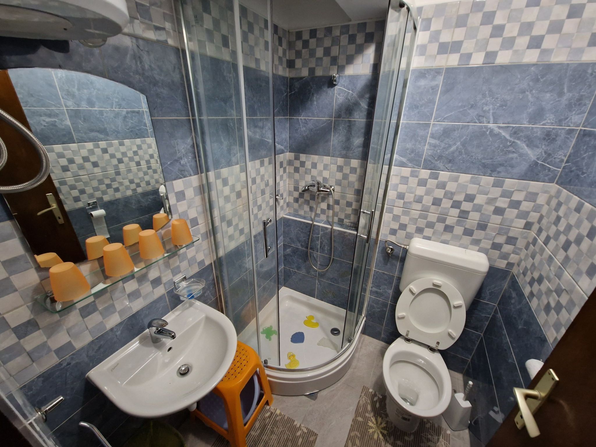 Ein Badezimmer mit Duschkabine, Waschbecken und Toilette.