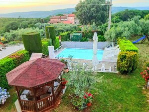 A pool area with a wooden deck, a gazebo, and a view of the surrounding landscape. - mit beheiztem Pool by Interhome (Buje)