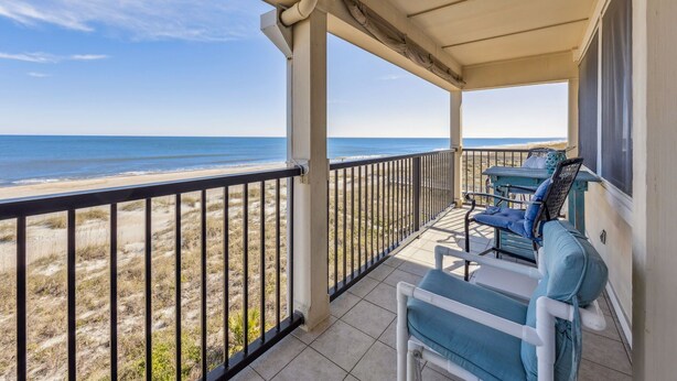 A covered balcony with a view of the beach and ocean. - Oceanfront 2BR Condo with Balcony & Beach Access (Fernandina Beach)