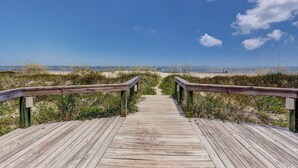 A wooden boardwalk leading to a beach with a clear sky. - Oceanfront 2BR Condo with Balcony & Beach Access (Fernandina Beach)
