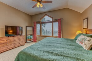 A bedroom with a bed, dresser, TV, window with curtains, and a ceiling fan. - W12 Updated Townhome w/ Epic Ski Views, A/C & On-Site Trails Near Mt. Washington Hotel (Bretton Woods)