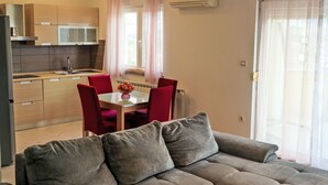 A modern kitchen with a dining area, a sofa, and a sliding glass door. - Appartement "Appartement Sarah" mit Balkon by Interhome (Buzdohanj)