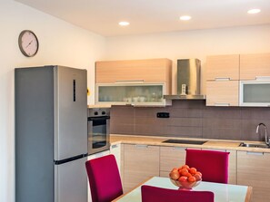 Eine moderne Küche mit Kühlschrank, Backofen, Mikrowelle und Spüle.