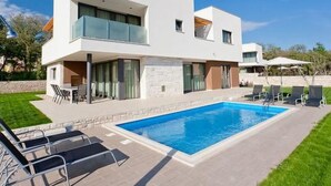 A modern two-story house with a swimming pool, outdoor seating, and a well-maintained lawn. - Designvilla mit Dachterrasse und Panoramablick by Interhome (Novigrad (Istra))