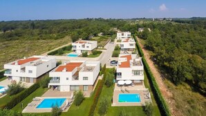A modern residential area with multiple two-story houses, each featuring a swimming pool and a well-maintained lawn. - Designvilla mit Dachterrasse und Panoramablick by Interhome (Novigrad (Istra))