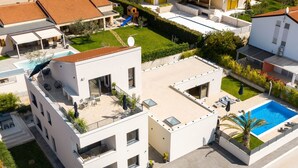 A modern two-story building with a rooftop pool, a covered outdoor seating area, and a small children's play structure. - Studio Apartment Soulshine by Interhome (Novigrad (Istra))