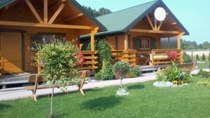 A wooden cabin with a porch and a small garden area. - in Rusinowo mit Terrasse und Garten by Interhome (Rusinowo)